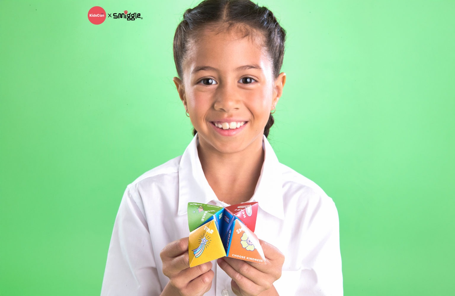 Photo of a young girl smiling, holding a Kindness chatterbox